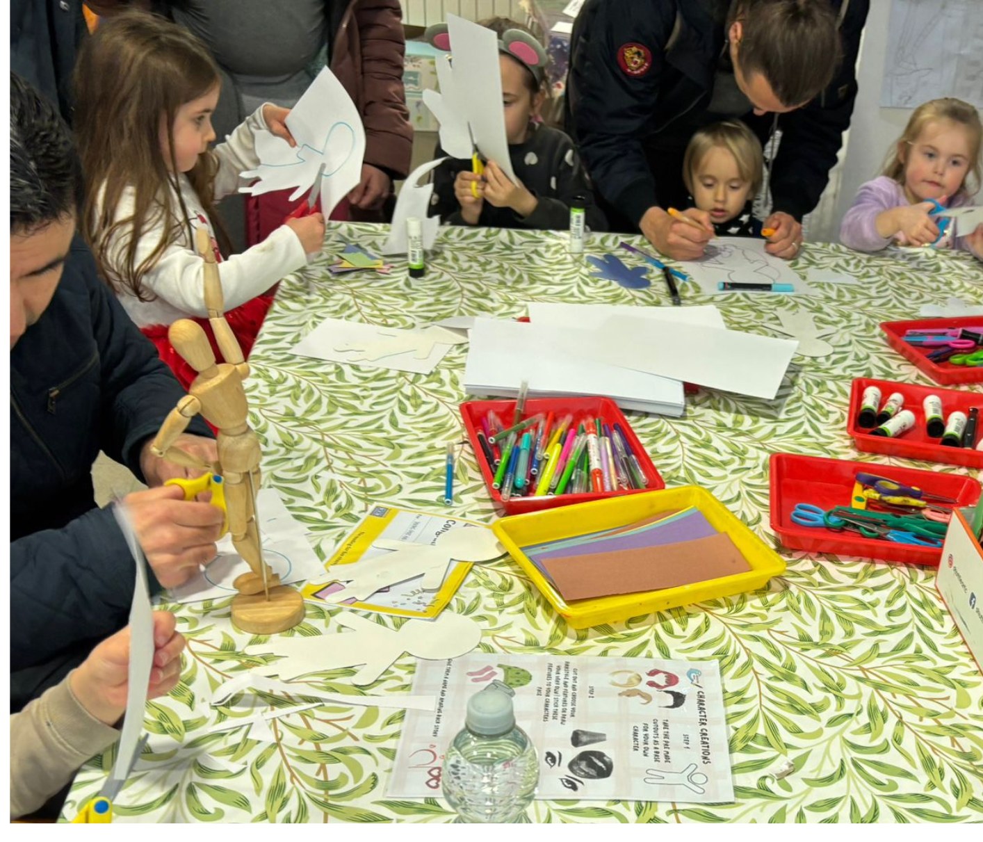 Volunteers helping children at a craft table