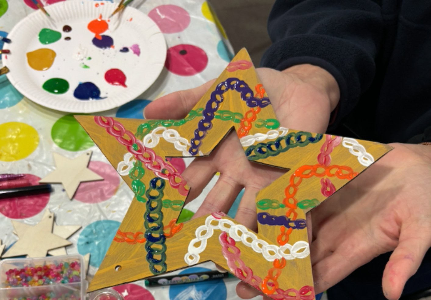 Hands holding a hand-painted wooden star
